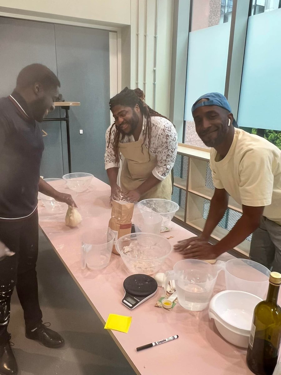Members preparing food together in the kitchen before service